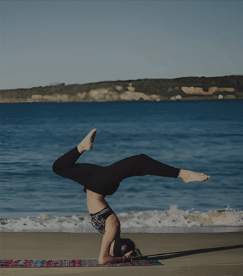 A person doing a handstand on the beach