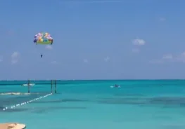 A person parasailing in the ocean with a parachute.